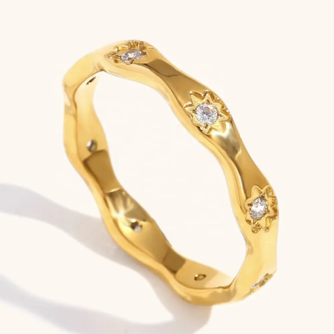 Gold ring with diamond accents on a white background