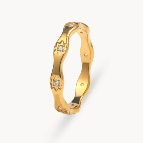 Gold ring with diamond accents on a white background