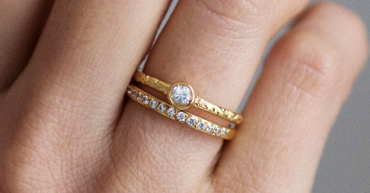 Someone wearing two gold eternity rings