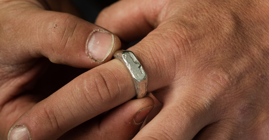 A man putting on a silver ring on his index finger