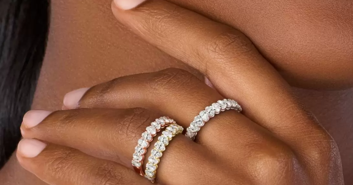 A woman wearing 3 eternity rings on one hand