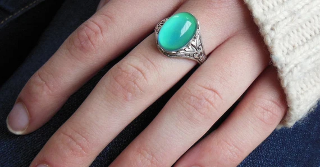 A cyan mood ring on someones finger