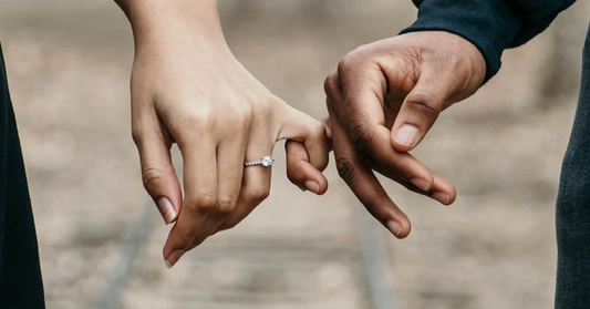 A man and woman holding hands while wearing promise rings