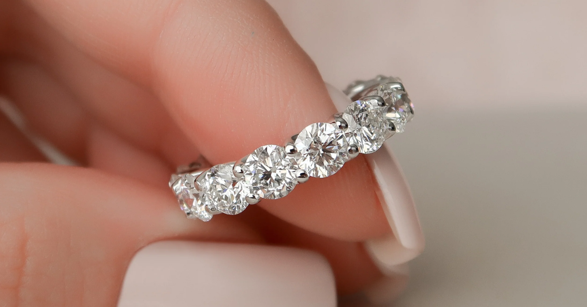A woman holding a diamond eternity band ring