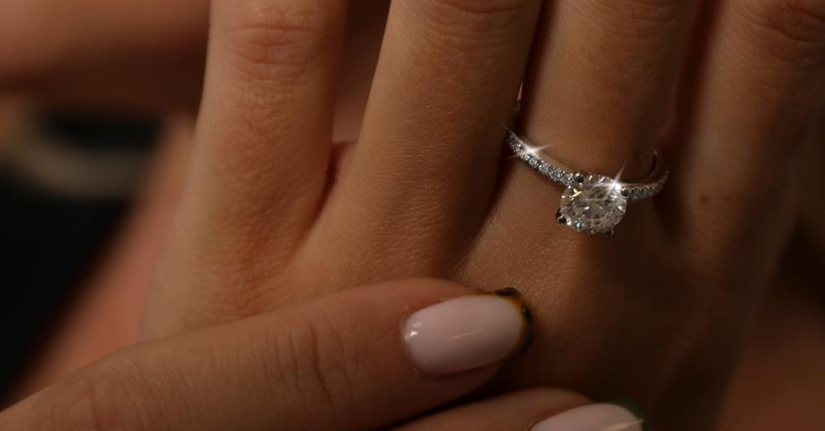 A lady wearing a silver diamond solitaire ring