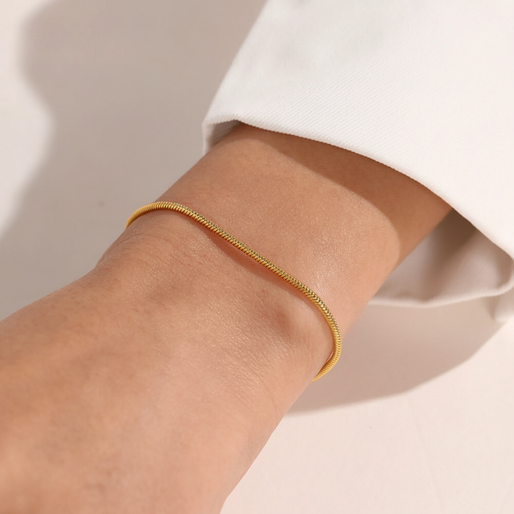 Gold snake chain bracelet worn on wrist